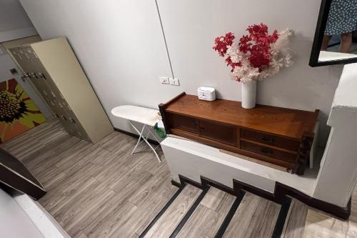 a room with a dresser with a vase of flowers on it at Orchid Hostel in Bangkok