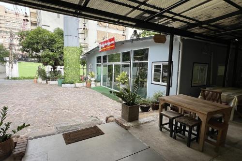 a patio with a table and chairs in front of a building at Orchid Hostel in Bangkok