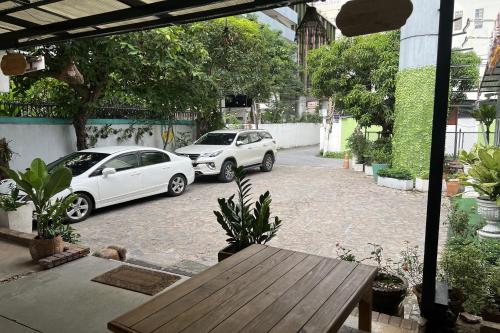 two white cars parked in a parking lot at Orchid Hostel in Bangkok
