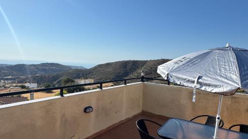 a balcony with a table and an umbrella at Olympus Holiday villa in Pissouri