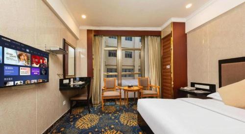 a hotel room with a bed and a table and chairs at Zhongshan Hui Quan Hotel in Zhongshan