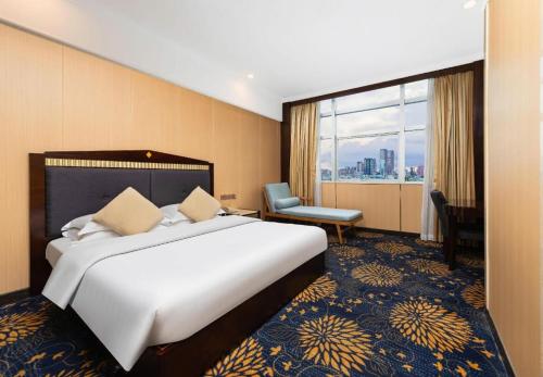 a hotel room with a large bed and a window at Zhongshan Hui Quan Hotel in Zhongshan