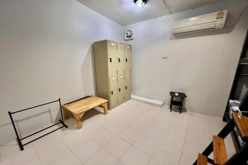 an empty room with a locker and a bench at Orchid Hostel in Bangkok