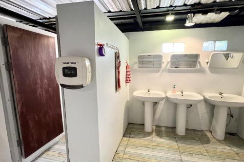 a bathroom with three sinks in a room at Orchid Hostel in Bangkok