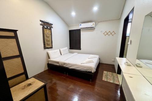 a small room with a bed and a mirror at Orchid Hostel in Bangkok