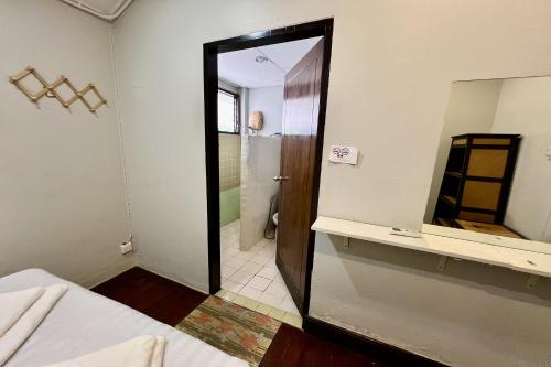 a bathroom with a mirror and a bed in it at Orchid Hostel in Bangkok