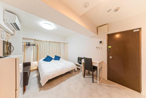 a hotel room with a bed and a desk and a table at 元町翡翠ビル in Yokohama