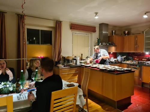 a group of people sitting in a kitchen at Appartements Fortuna in Pertisau