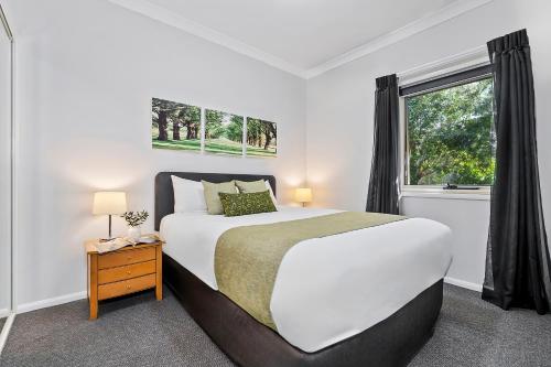una camera da letto con un letto grande e una finestra di Emerald Inn by Travellers a Emerald