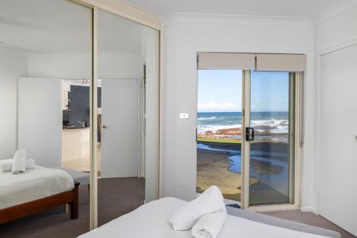 a bedroom with two beds and a view of the ocean at Hear the waves watch the whales Anna Bay in Anna Bay
