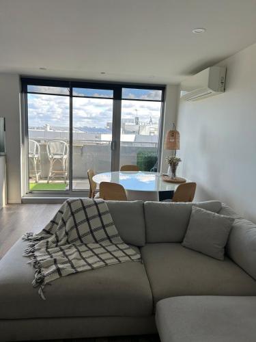 a living room with a couch and a table at Penthouse with Stunning Melbourne Skyline View in Bulleen