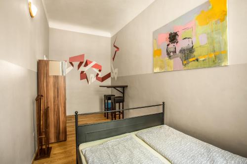 a bedroom with a bed and a painting on the wall at Ahoy! Hostel in Prague