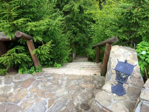 a garden with a stone walkway with a stone wall at Villa Alpiyka in Slavske