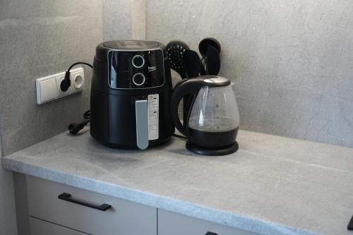 a kitchen counter with a coffee maker and a blender at Kuncų apartments, self-check in, free parking, cozy in Klaipėda