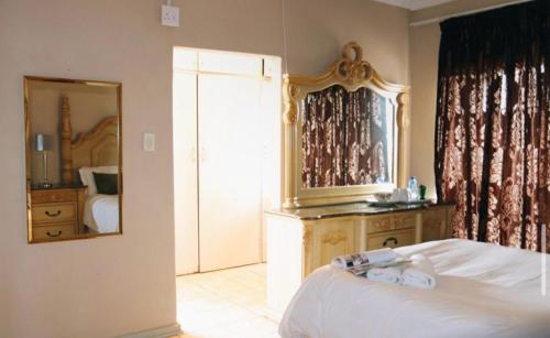 a bedroom with a bed and a large mirror at 54 River Logde in Mokopane