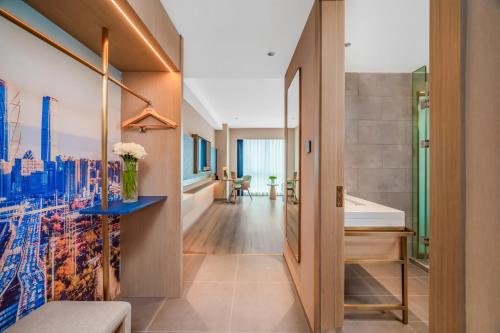 a hallway leading to a bathroom with a shower and a sink at Kyriad Hotel Kunming Xishan Wanda Plaza Railway Station in Kunming