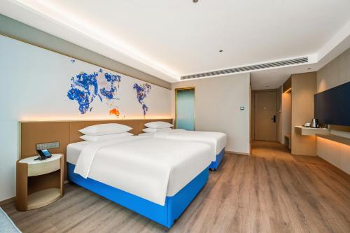 Ένα ή περισσότερα κρεβάτια σε δωμάτιο στο Kyriad Hotel Kunming Xishan Wanda Plaza Railway Station