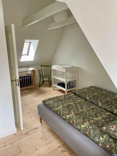 a bedroom with a bed and a room with a window at Charming Townhome Near Beach And Square in Ærøskøbing