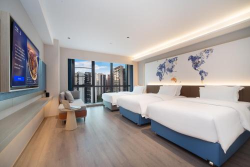 a hotel room with three beds and a tv at Kyriad Hotel Kunming Xishan Wanda Plaza Railway Station in Kunming
