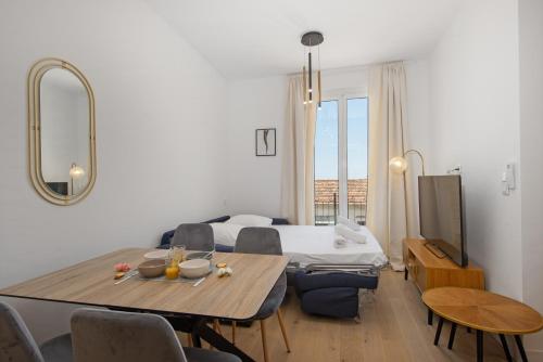 un salon avec une table et un lit dans l'établissement Abba terrasse, à Cap d'Ail