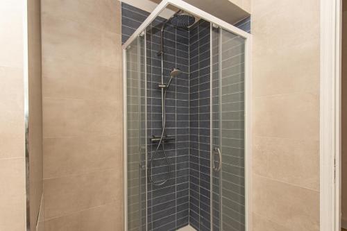 une douche avec une porte vitrée dans une salle de bain dans l'établissement Abba terrasse, à Cap d'Ail