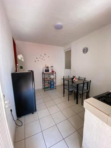 a kitchen with a black refrigerator and a table at Pequeño apartamento Aeropuerto CDMX in Mexico City