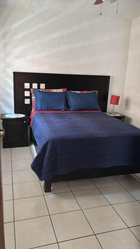 a bedroom with a large blue bed with blue pillows at Pequeño apartamento Aeropuerto CDMX in Mexico City