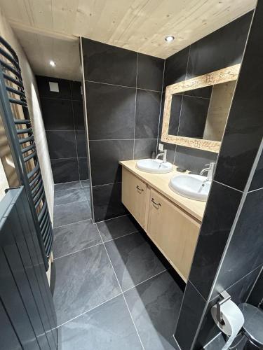 a bathroom with two sinks and a mirror at Le Pacheu in Les Crosets
