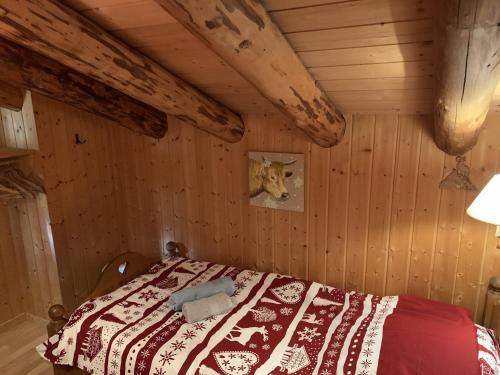 a bedroom with a bed in a wooden room at Le Pacheu in Les Crosets