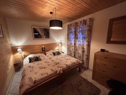 a bedroom with a bed and a wooden ceiling at Le Pacheu in Les Crosets
