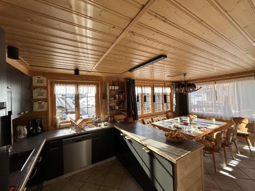 a kitchen with a wooden ceiling and a table at Le Pacheu in Les Crosets