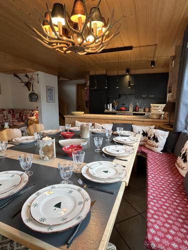 a long table with plates and glasses on it at Le Pacheu in Les Crosets