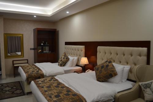 a hotel room with two beds and a lamp at Dar Al Wedad Hotel in Jeddah