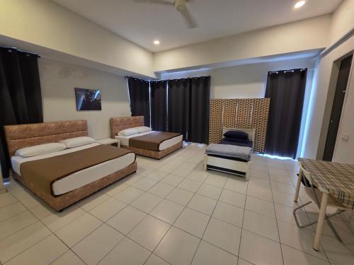 a hotel room with two beds and a chair at Selendang In Krubong Near Std Hang Jebat, MITC & UTEM in Melaka