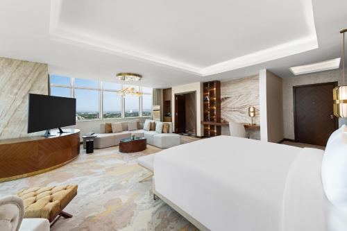 a large room with a large bed and a living room at Movenpick Hotel Centaurus Islamabad in Islamabad