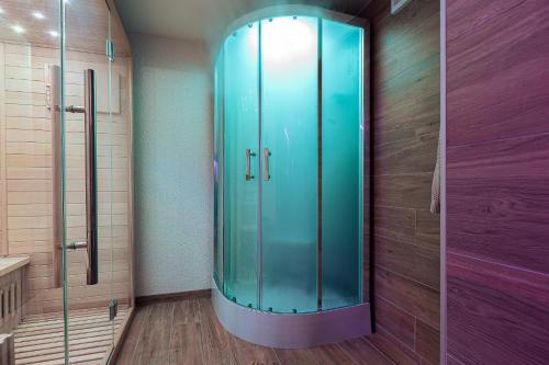 a glass shower in a bathroom with a wooden floor at PerfectSpa Wellness Apartment in Humenné