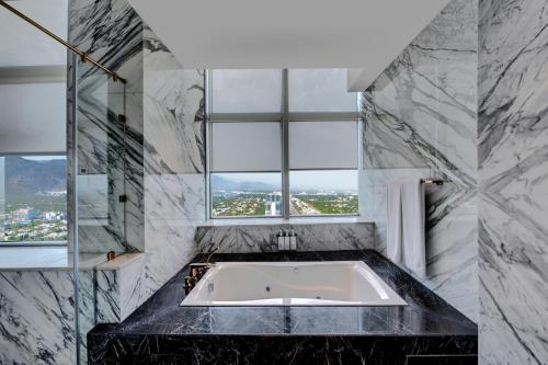a bath tub in a bathroom with a window at Movenpick Hotel Centaurus Islamabad in Islamabad