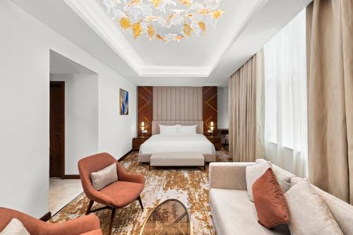a hotel room with a bed and two chairs at Movenpick Hotel Centaurus Islamabad in Islamabad