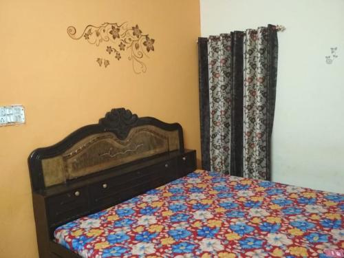 a bedroom with a bed with a floral comforter at Virat Home in Gwalior