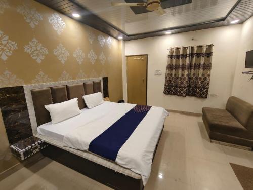 a bedroom with a large bed and a chair at Virat Home in Gwalior