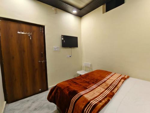 a bedroom with a large bed and a wooden door at Virat Home in Gwalior