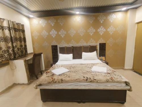 a bedroom with a large bed with two laptops on it at Virat Home in Gwalior