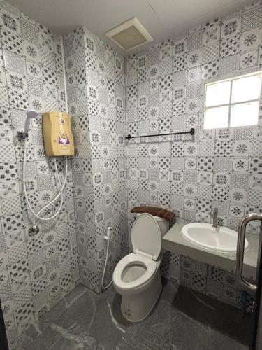 a bathroom with a toilet and a sink at Lithai Guesthouse in Phitsanulok