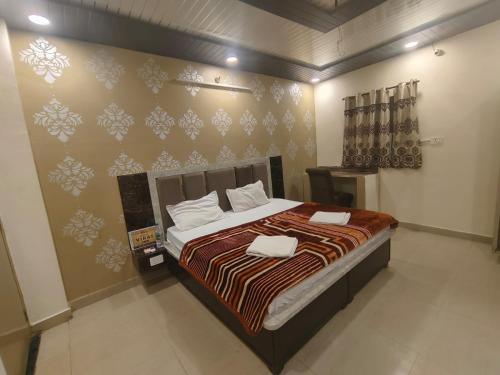 a bedroom with a bed and a wall with snowflake wallpaper at Virat Home in Gwalior