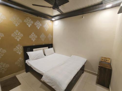a small bedroom with a white bed in it at Virat Home in Gwalior