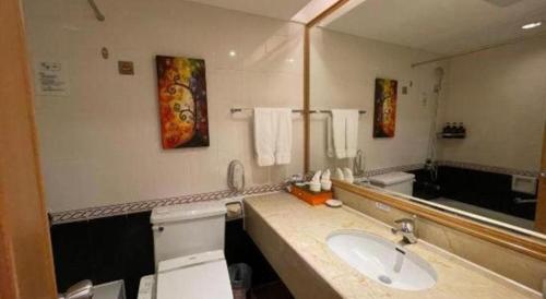 a bathroom with a sink and a large mirror at Xiamen Airlines Quanzhou Hotel in Quanzhou