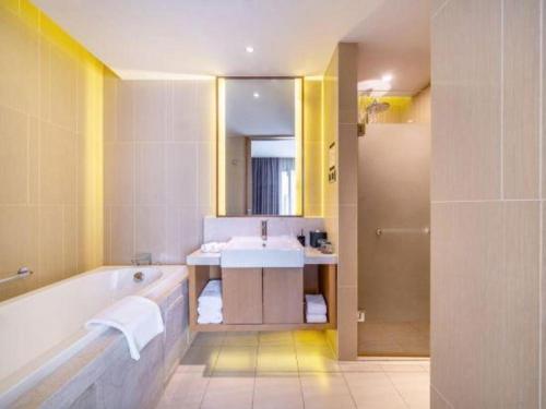 a bathroom with a tub and a sink at Wojo Hotel in Tashan