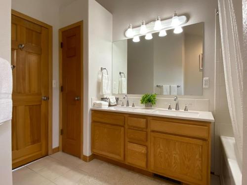 a bathroom with a sink and a large mirror at Echo Hills Mountain Lodge - Evergreen Mountain Top Retreat - 15 minutes to SKI!! in Evergreen