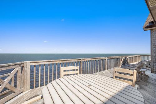 a deck with two chairs and a table on the beach at 8650 - Mare Vista Retreat in Frisco