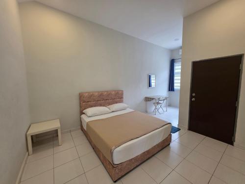 a bedroom with a large bed and a table at Selendang In Krubong Near Std Hang Jebat, MITC & UTEM in Melaka